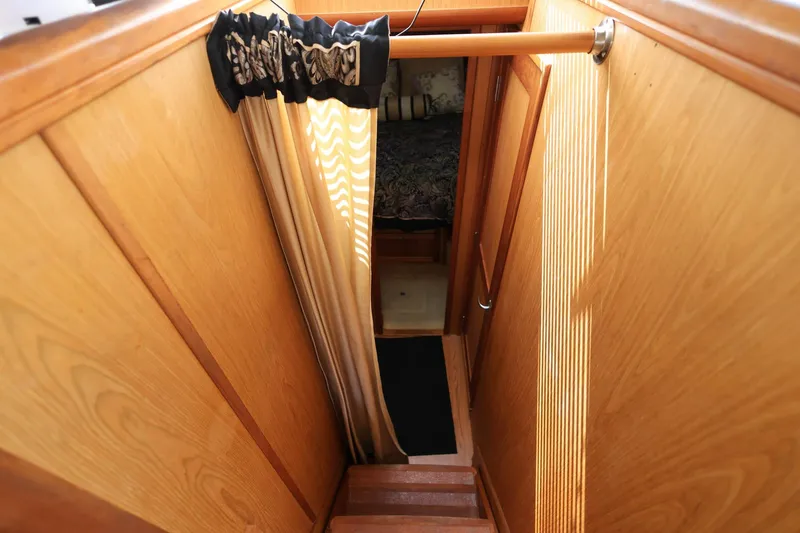 Slide: The Image of Interior view of 2005 Mainship 40 Trawler, featuring wooden stairs and cozy cabin entrance. - 26