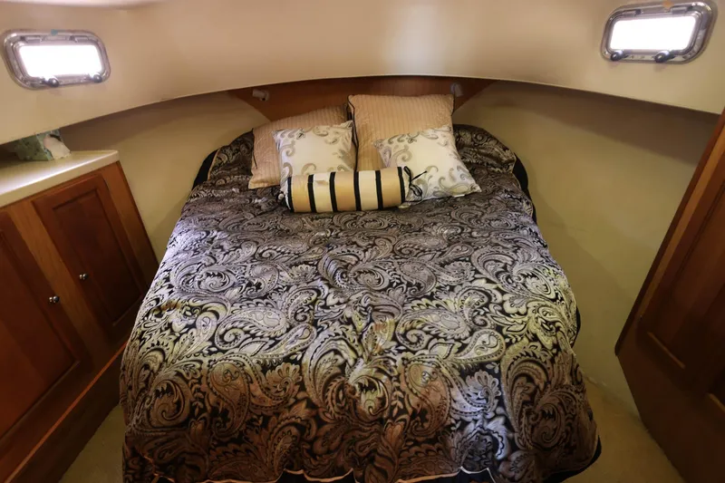 Slide: The Image of Cozy bedroom in 2005 Mainship 40 Trawler with elegant bedding and wooden cabinetry. - 27