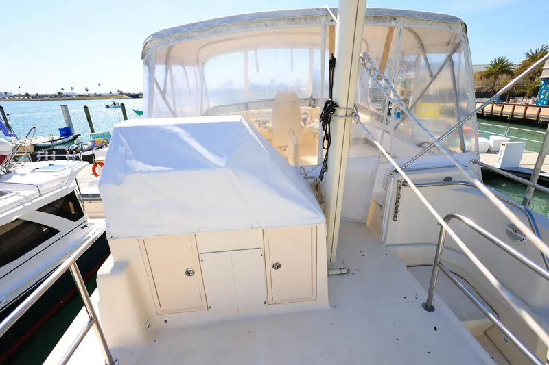 Slide: The Image of 2005 Mainship 40 Trawler on dock, featuring covered helm and clear enclosure. - 31