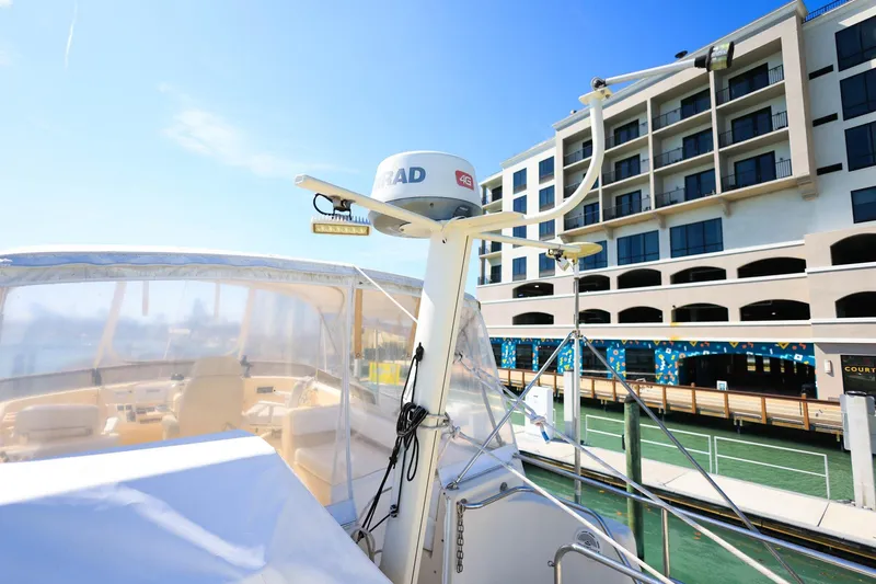 Slide: The Image of 2005 Mainship 40 Trawler docked near modern building under clear blue sky. - 34