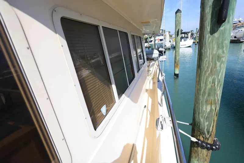 Slide: The Image of 2005 Mainship 40 Trawler docked, showcasing side view and windows. - 36