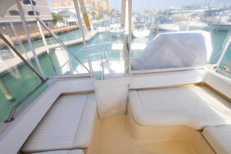 Slide: The Image of 2005 Mainship 40 Trawler interior with white seating, overlooking marina. - 37