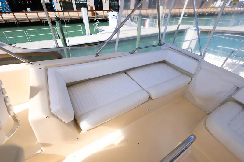 Slide: The Image of 2005 Mainship 40 Trawler interior with white cushioned seating and marina view. - 38