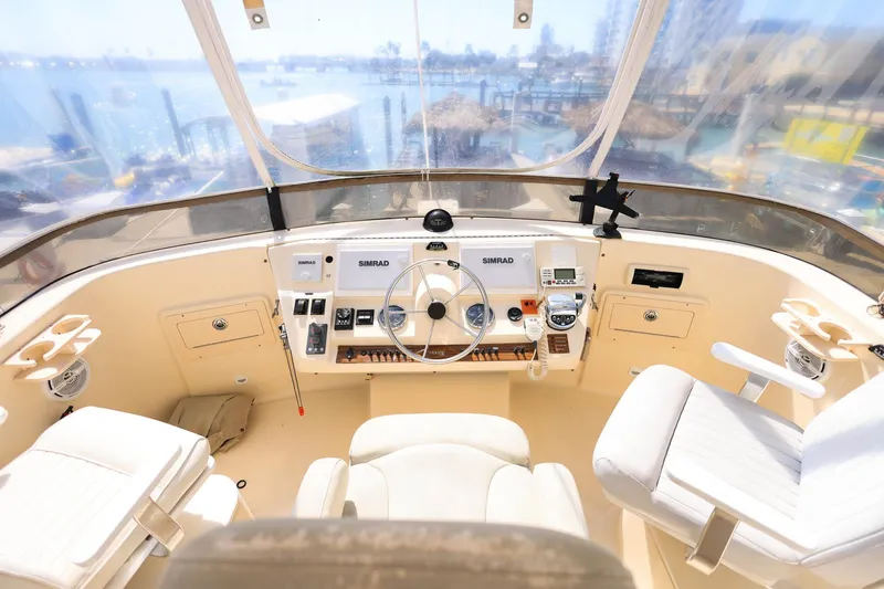Slide: The Image of 2005 Mainship 40 Trawler helm with Simrad electronics, featuring dual captain chairs and panoramic view. - 41