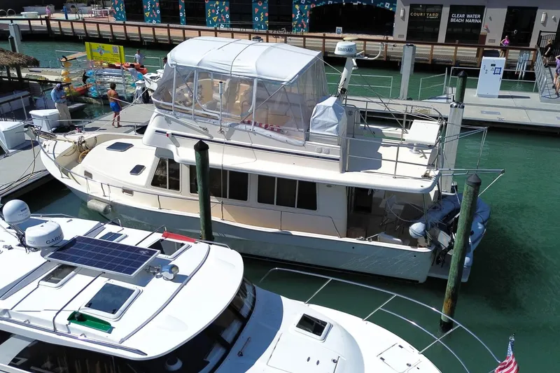 Slide: The Image of 2005 Mainship 40 Trawler docked at marina, featuring upper deck enclosure. - 5