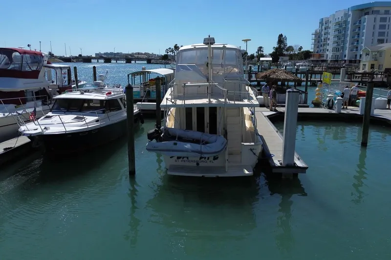 Slide: The Image of 2005 Mainship 40 Trawler docked at marina, surrounded by other boats and waterfront buildings. - 6