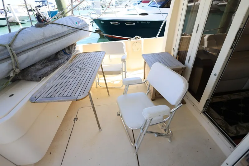 Slide: The Image of 2005 Mainship 40 Trawler deck with chairs, table, and docked boats in background. - 9