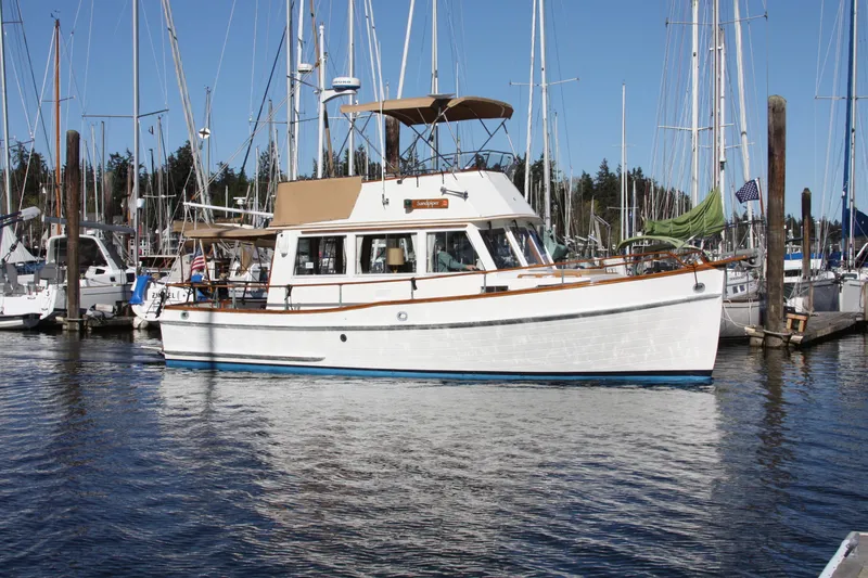 The Image of 1983 Grand Banks 32 Sedan yacht docked in a marina, surrounded by sailboats. - 0