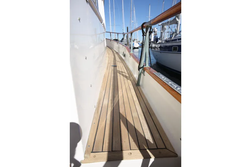 Slide: The Image of 1983 Grand Banks 32 Sedan yacht with teak deck and railing in marina. - 10