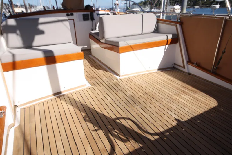 Slide: The Image of Spacious deck of 1983 Grand Banks 32 Sedan with wooden flooring and cushioned seating. - 12