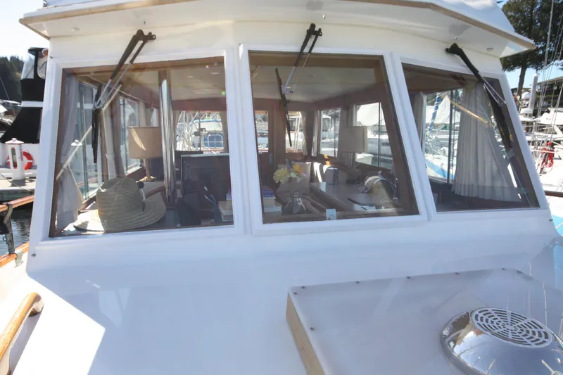 Slide: The Image of 1983 Grand Banks 32 Sedan boat interior view with windows and nautical decor. - 13