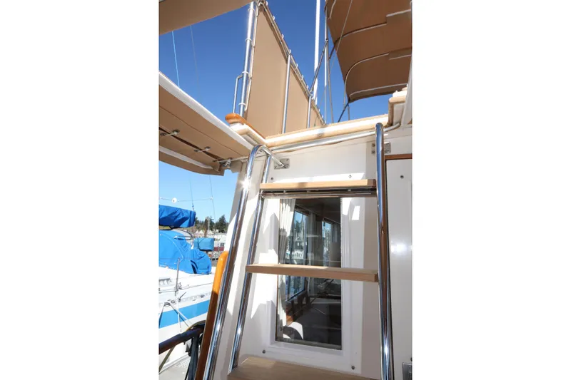 Slide: The Image of 1983 Grand Banks 32 Sedan yacht ladder and deck view under clear blue sky. - 15
