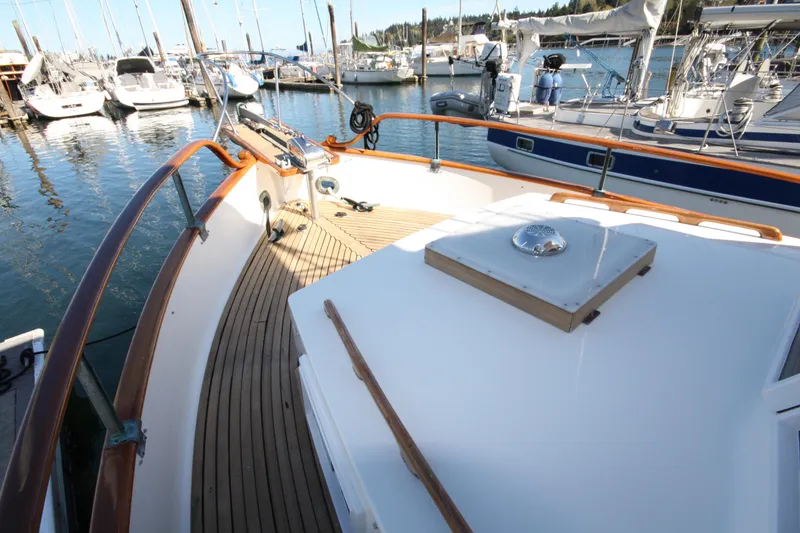 Slide: The Image of 1983 Grand Banks 32 Sedan yacht deck with wooden railings, docked at a marina. - 17