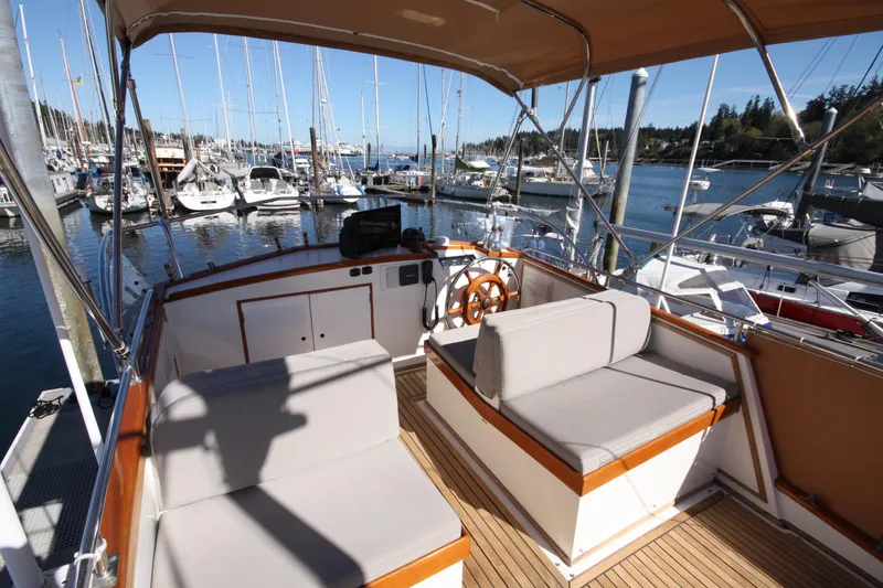 Slide: The Image of 1983 Grand Banks 32 Sedan yacht interior with seating, docked at a marina. - 19