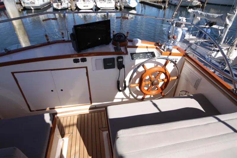 Slide: The Image of 1983 Grand Banks 32 Sedan helm with wooden wheel and nautical instruments. - 20