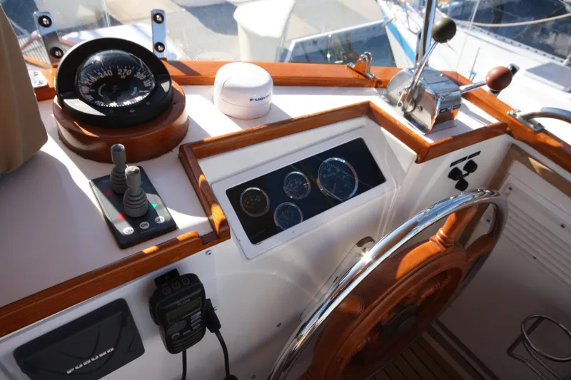 Slide: The Image of Helm of 1983 Grand Banks 32 Sedan with compass, gauges, and wooden steering wheel. - 22