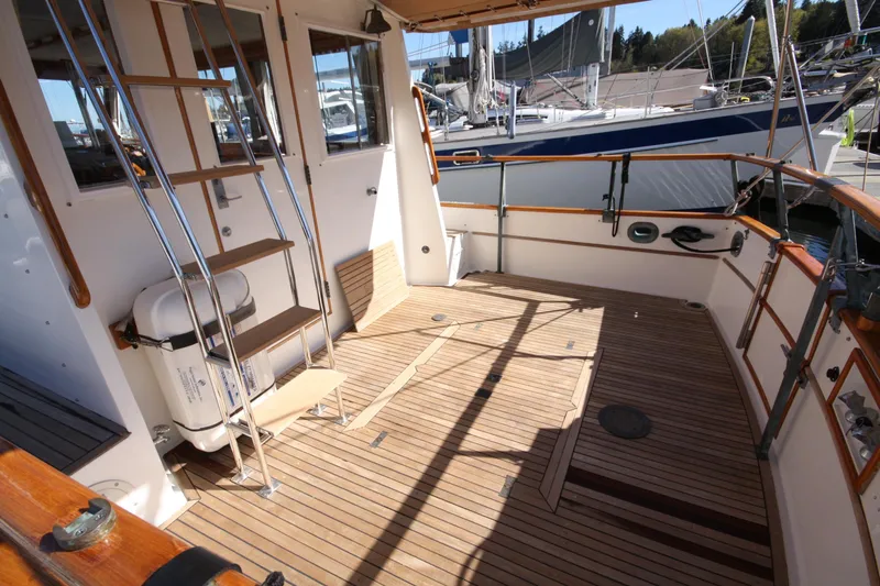 Slide: The Image of 1983 Grand Banks 32 Sedan boat deck with wooden flooring and metal ladder. - 23