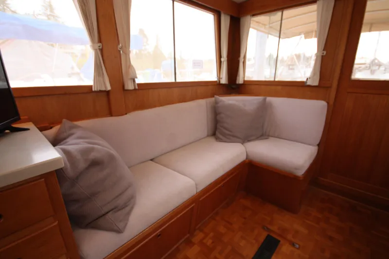 Slide: The Image of Interior of 1983 Grand Banks 32 Sedan with cozy corner seating and wooden accents. - 27