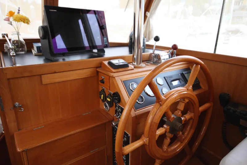 Slide: The Image of 1983 Grand Banks 32 Sedan helm with wooden wheel and modern navigation equipment. - 32