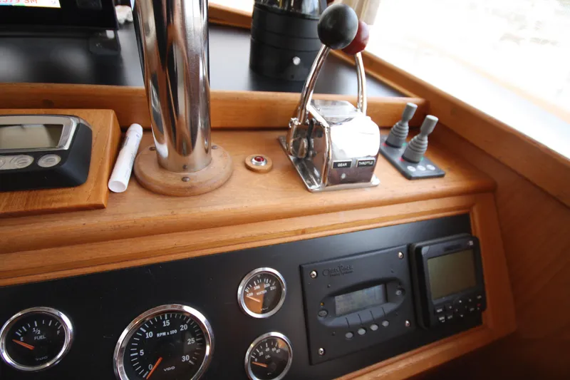 Slide: The Image of Control panel of a 1983 Grand Banks 32 Sedan boat with gauges and throttle. - 33
