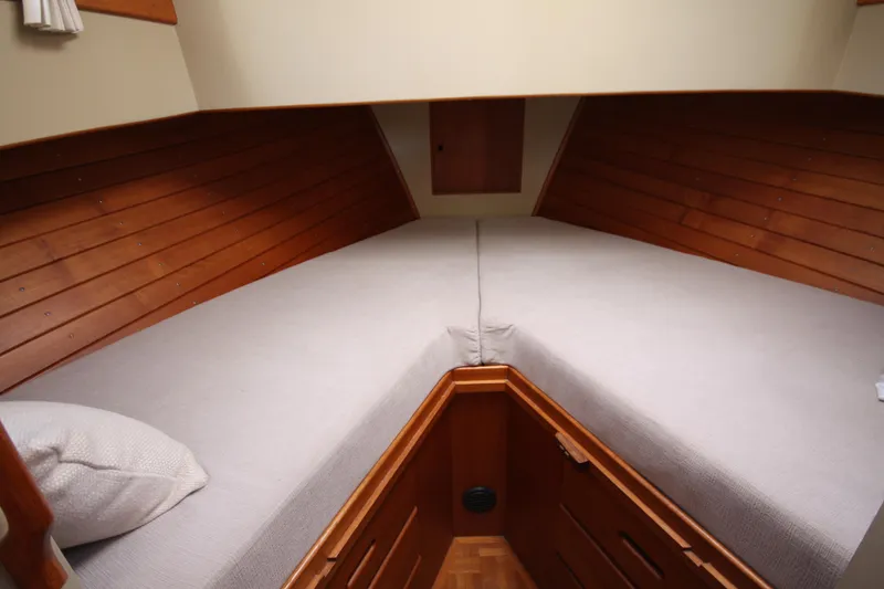 Slide: The Image of Interior cabin of 1983 Grand Banks 32 Sedan with wooden paneling and cozy bedding. - 38
