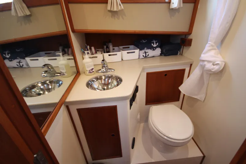 Slide: The Image of 1983 Grand Banks 32 Sedan bathroom with sink, mirror, and nautical-themed decor. - 41