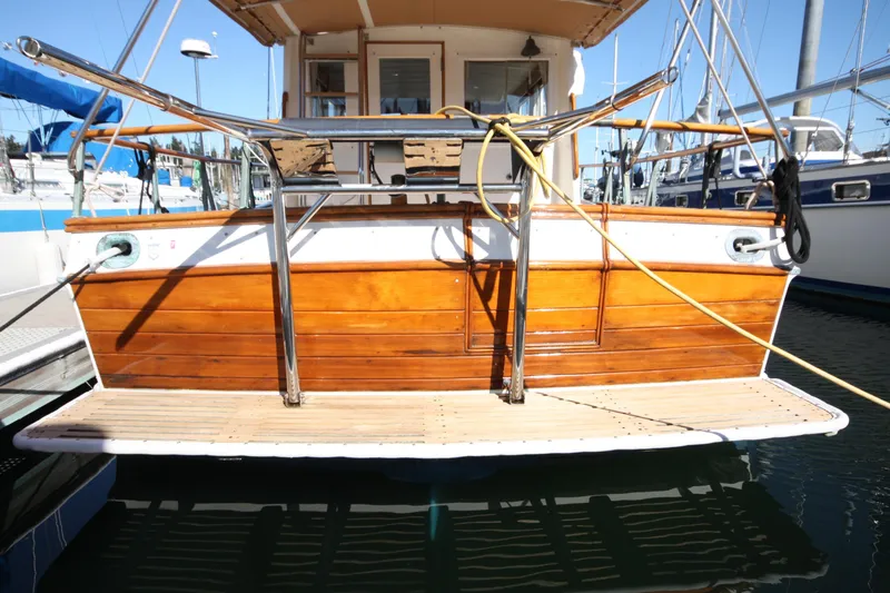 Slide: The Image of 1983 Grand Banks 32 Sedan with wooden deck and railing, docked at marina. - 60
