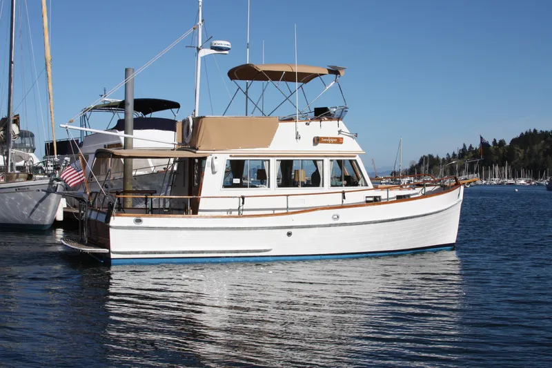 Slide: The Image of 1983 Grand Banks 32 Sedan boat docked in a serene marina setting. - 61