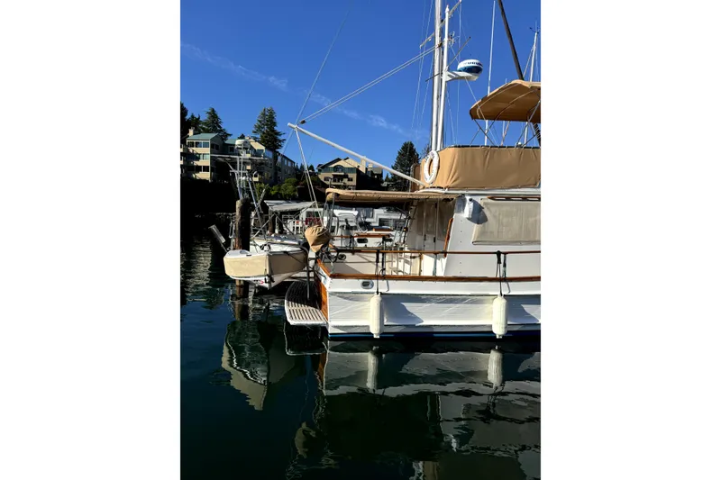 Slide: The Image of 1983 Grand Banks 32 Sedan yacht docked in a serene marina setting. - 64