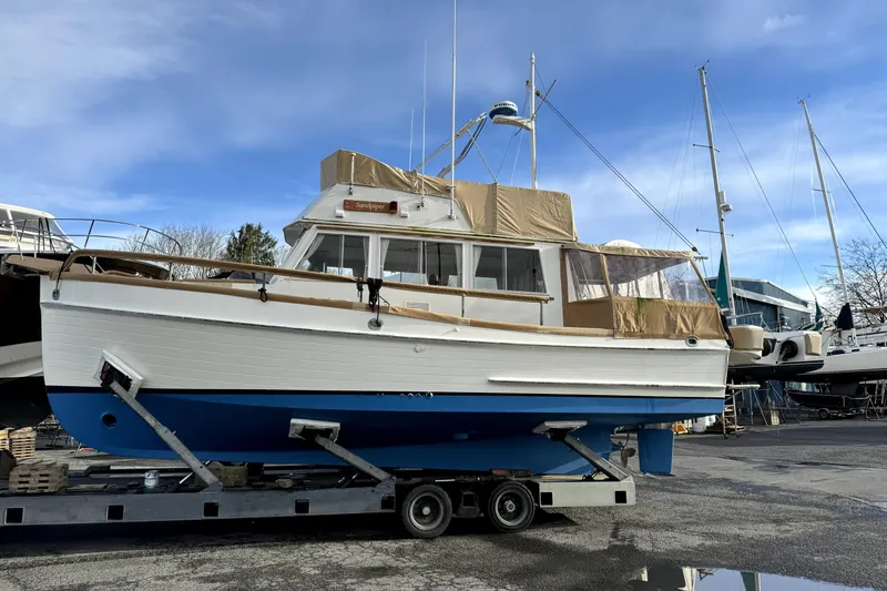 Slide: The Image of 1983 Grand Banks 32 Sedan boat on trailer, featuring classic design and blue hull. - 65
