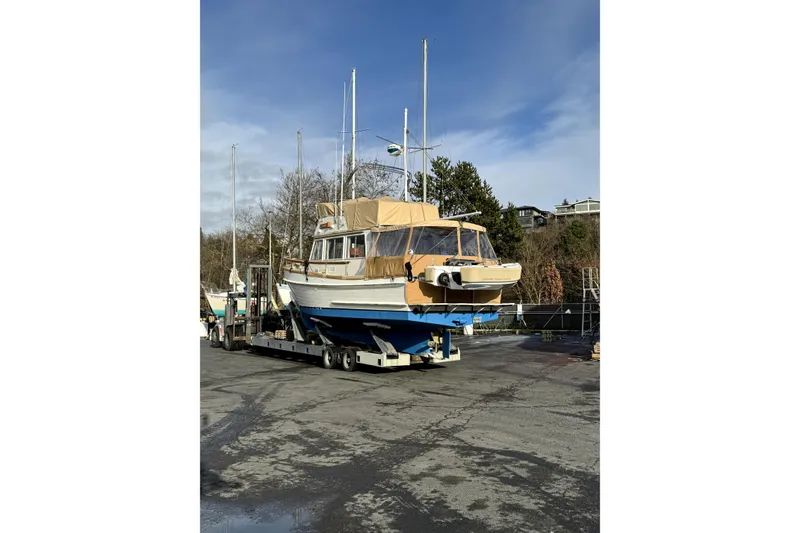 Slide: The Image of 1983 Grand Banks 32 Sedan boat on trailer, parked outdoors under clear sky. - 66