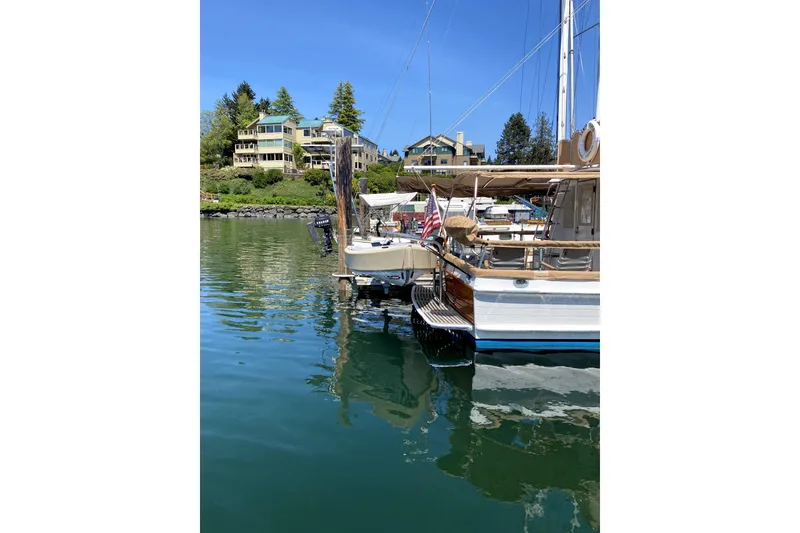 Slide: The Image of 1983 Grand Banks 32 Sedan docked in a scenic marina with waterfront homes. - 68