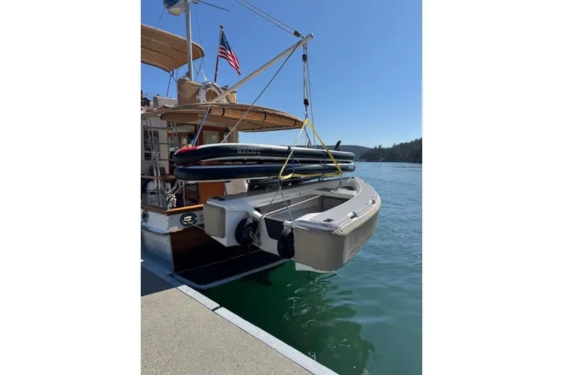 Slide: The Image of 1983 Grand Banks 32 Sedan with dinghy and paddleboard, docked on a sunny day. - 72