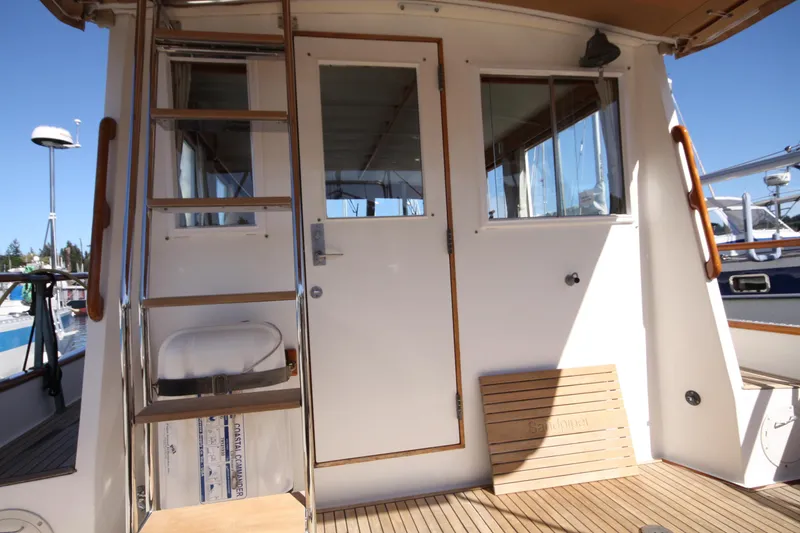 Slide: The Image of 1983 Grand Banks 32 Sedan boat deck with ladder and wooden seating. - 8