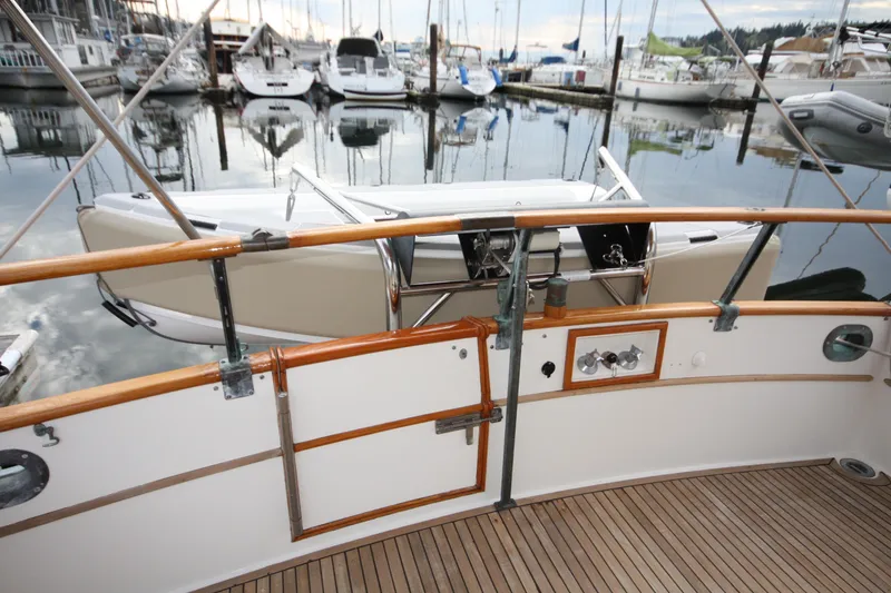 Slide: The Image of 1983 Grand Banks 32 Sedan yacht at marina, featuring wooden deck and railing. - 9