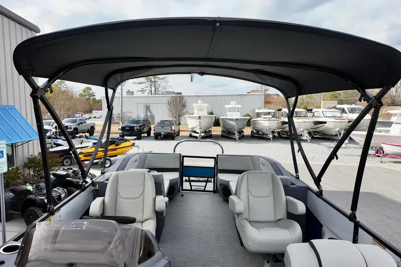 Slide: The Image of 2026 Sylvan A-22 LZ DH SPORT boat interior with canopy, parked at a marina. - 8