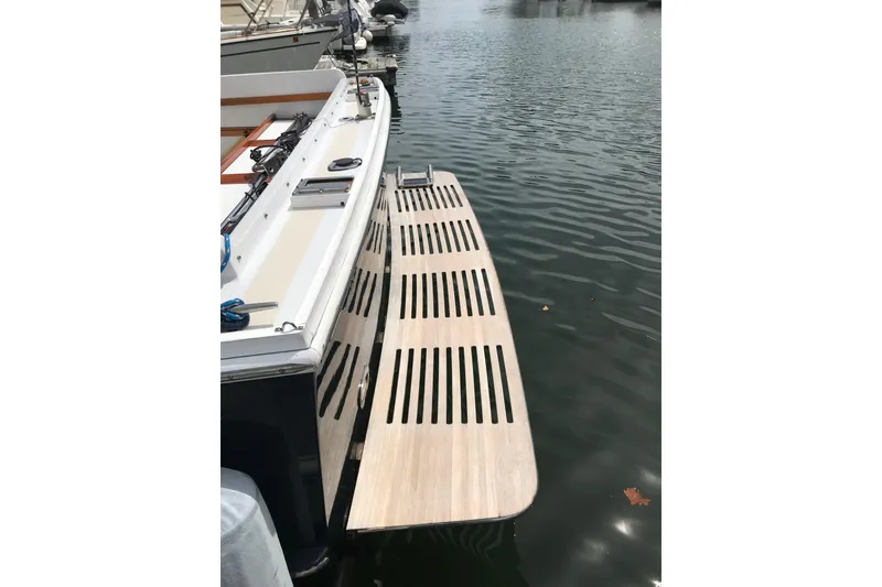 Slide: The Image of 1987 Wilbur 38 boat with wooden swim platform on calm water. - 11