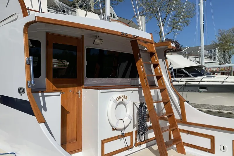 Slide: The Image of 1987 Wilbur 38 boat with wooden ladder and door, docked at marina. - 12