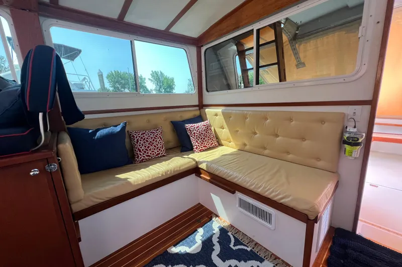 Slide: The Image of Cozy interior of 1987 Wilbur 38 boat with cushioned seating and decorative pillows. - 15