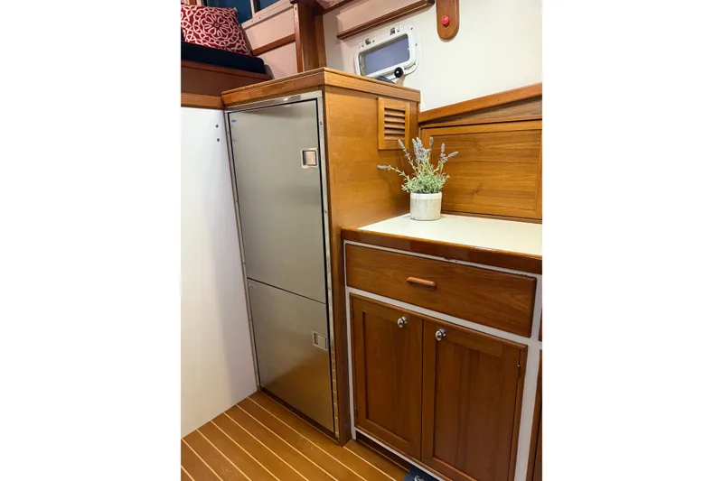 Slide: The Image of 1987 Wilbur 38 yacht interior with wooden cabinetry and stainless steel fridge. - 23