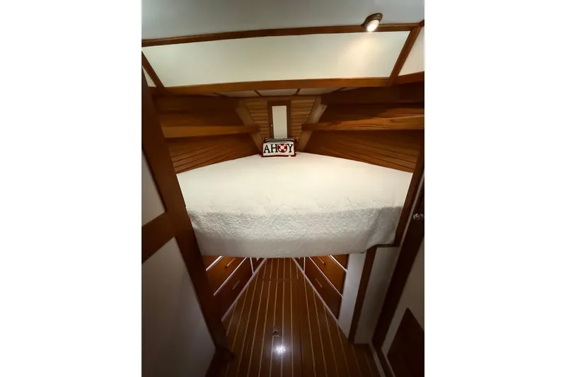 Slide: The Image of Cozy cabin interior of 1987 Wilbur 38 boat with wooden accents and "Ahoy" sign. - 26