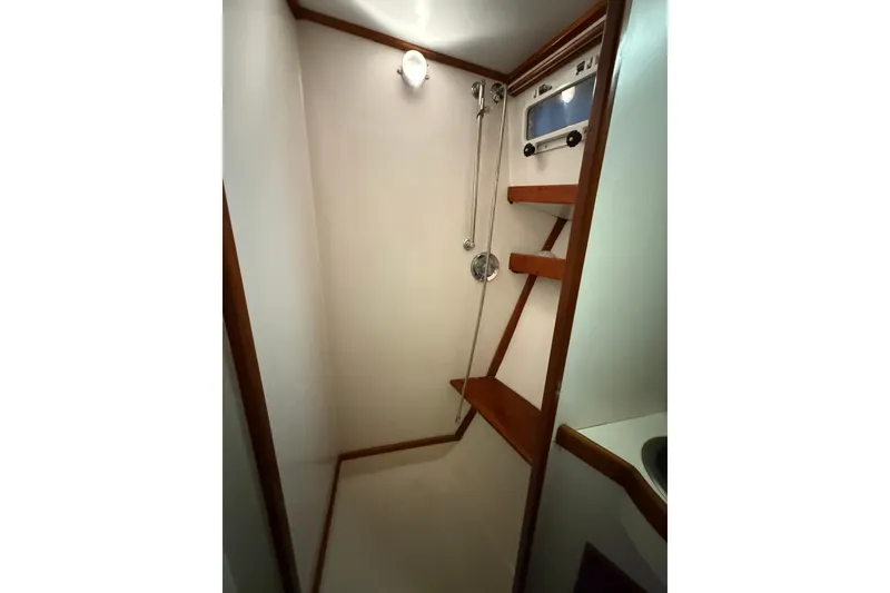 Slide: The Image of Shower area in 1987 Wilbur 38 boat with wooden shelves and light fixture. - 30