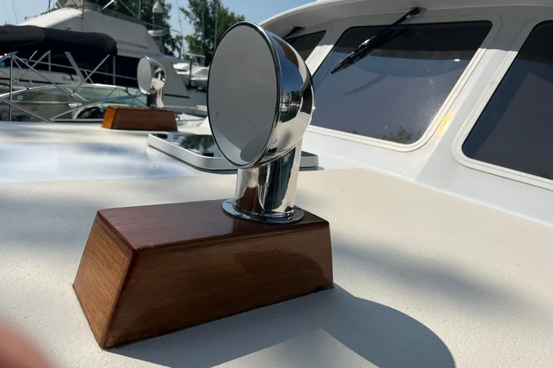 Slide: The Image of Chrome vent on 1987 Wilbur 38 boat deck, with wooden base and nearby yachts. - 31