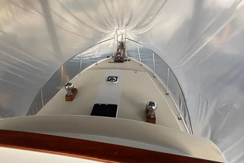 Slide: The Image of 1987 Wilbur 38 boat under protective cover, showcasing deck and railings. - 36