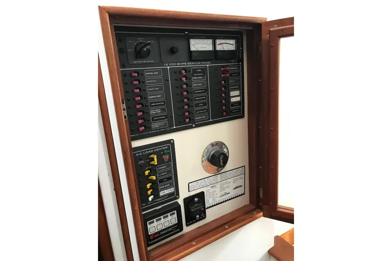 Slide: The Image of Electrical control panel on a 1987 Wilbur 38 boat, featuring switches and gauges. - 42