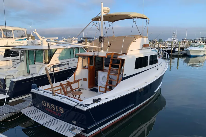 Slide: The Image of 1987 Wilbur 38 boat named "Oasis" docked at a marina. - 48