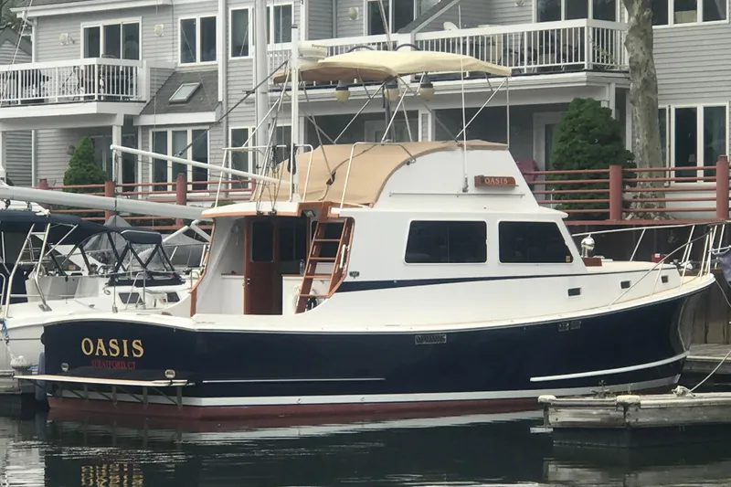 Slide: The Image of 1987 Wilbur 38 boat named Oasis docked near waterfront homes. - 5