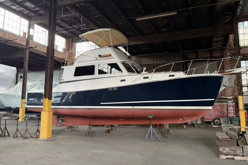 Slide: The Image of 1987 Wilbur 38 boat in a warehouse, elevated on stands for maintenance. - 6