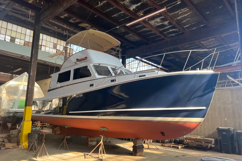 Slide: The Image of 1987 Wilbur 38 boat in a warehouse, elevated on stands for maintenance. - 7