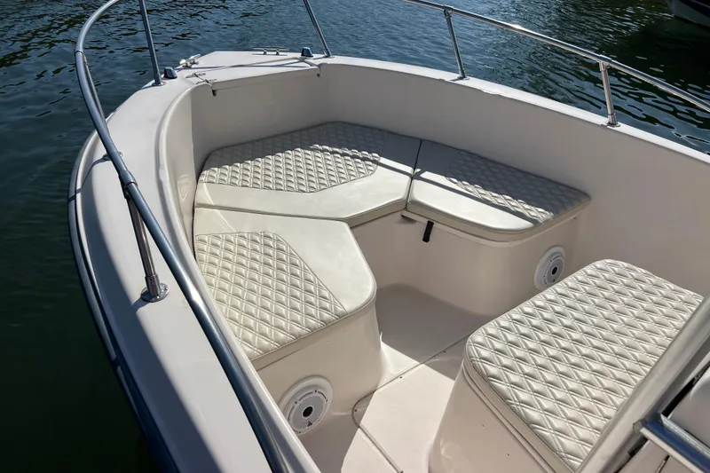 Slide: The Image of 1999 Grady-White Escape 209 boat interior with cushioned seating and railing. - 10
